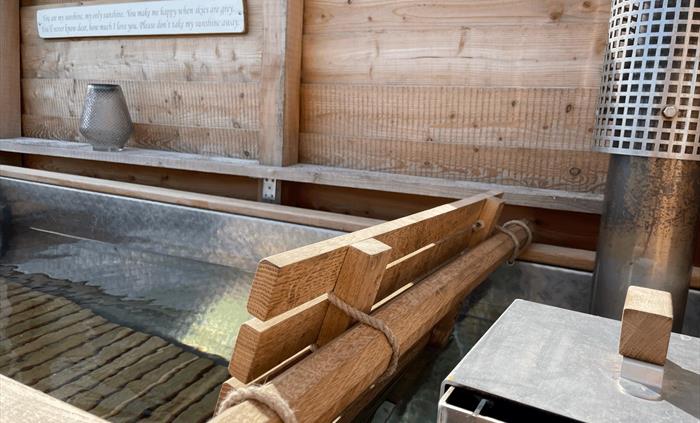 The wood fired hot tub filled with fresh water with the log burner ready to light